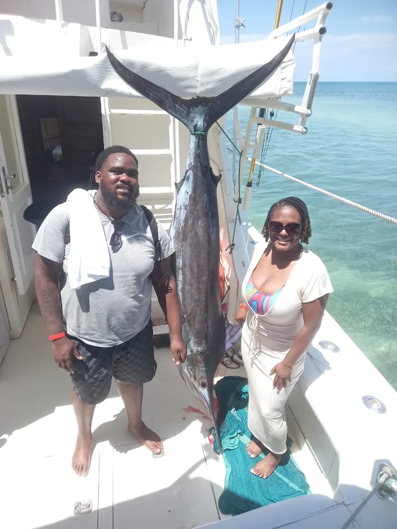 Couple with their trophy catch on a Montego Bay fishing charter