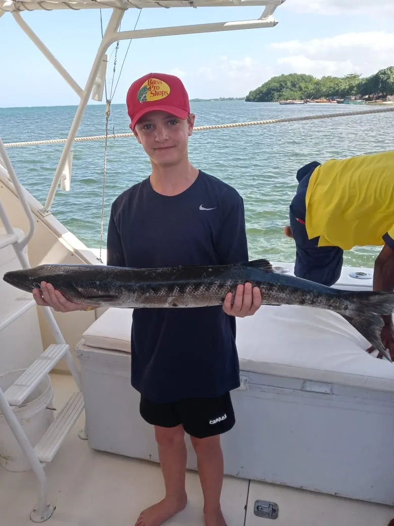 Young angler holding a catch in Montego Bay, Jamaica